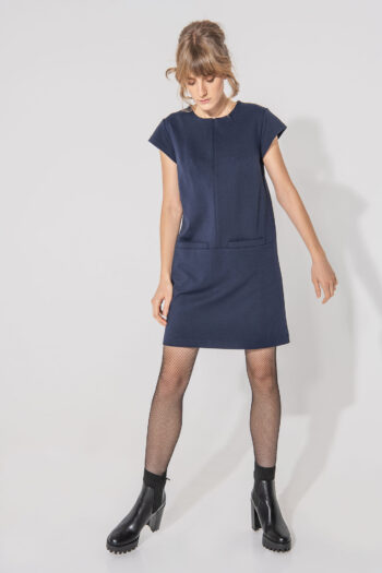Dark blue trapeze dress with big front pockets looking down • Sassa Björg