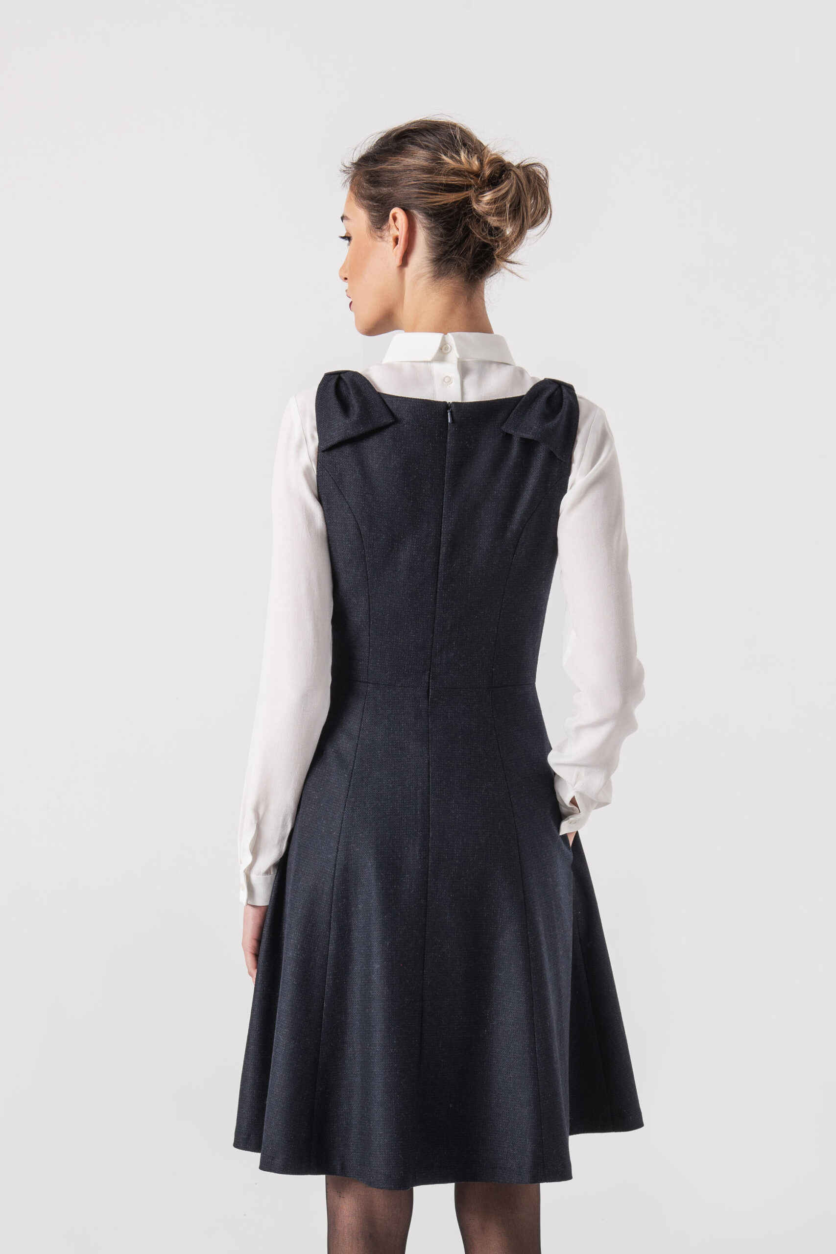 Navy blue pinafore dress with bow straps and side pockets back scaled • Sassa Björg