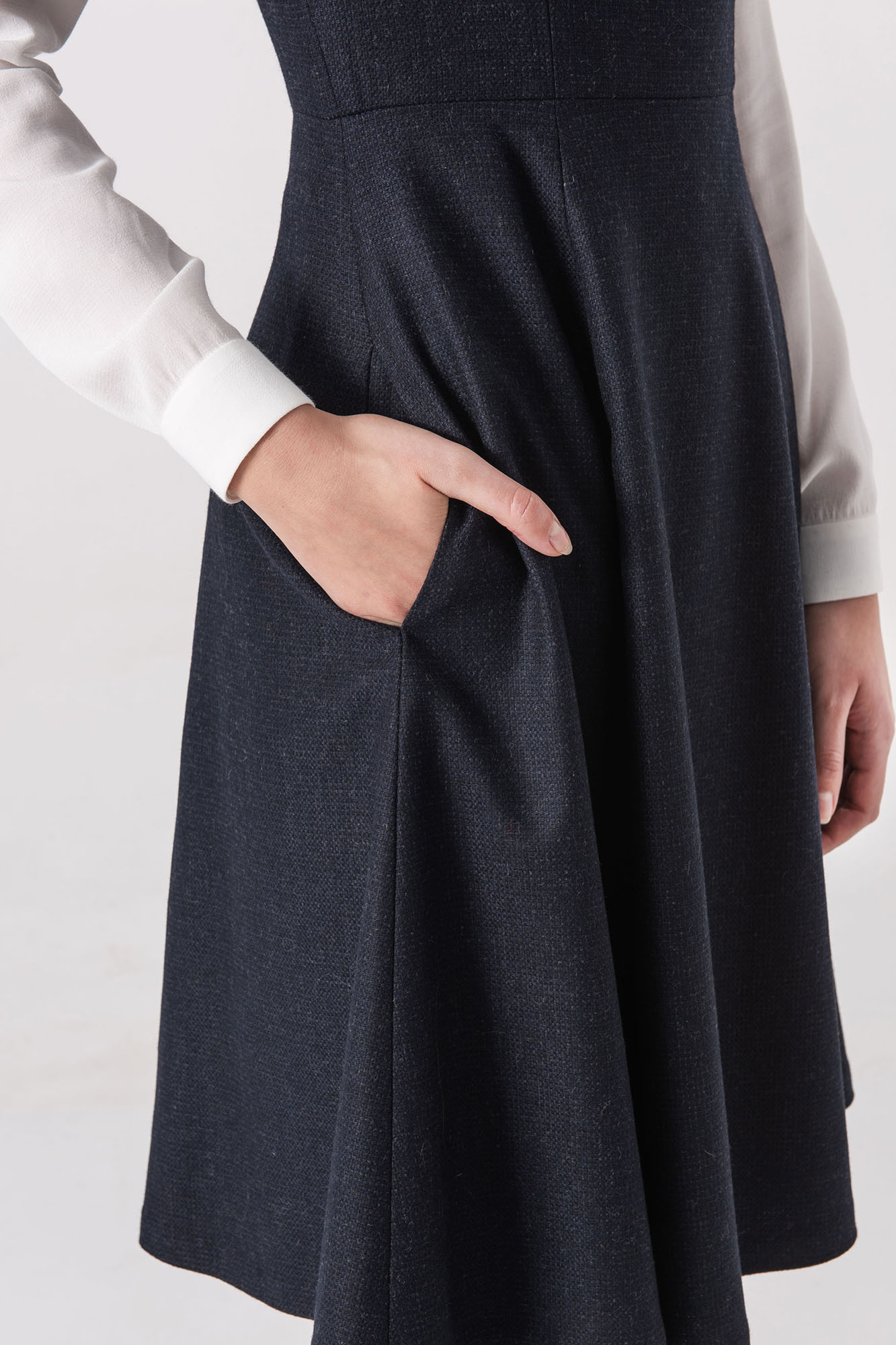 Navy blue pinafore dress with bow straps and side pockets close up • Sassa Björg
