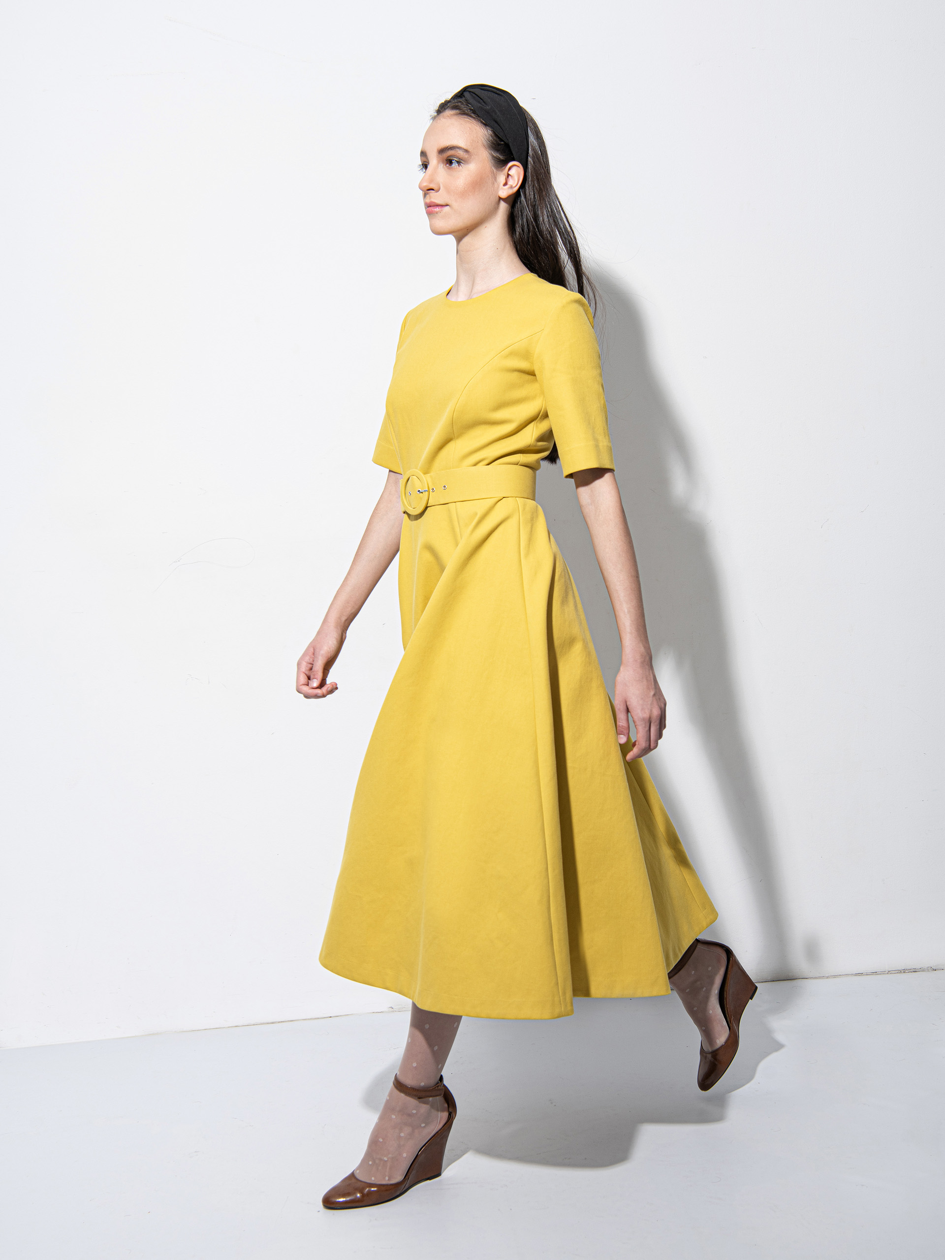 Mustard yellow dress with a belt walking • Sassa Björg